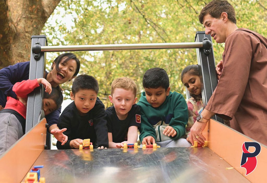 Children and adults playing together at a playground slide