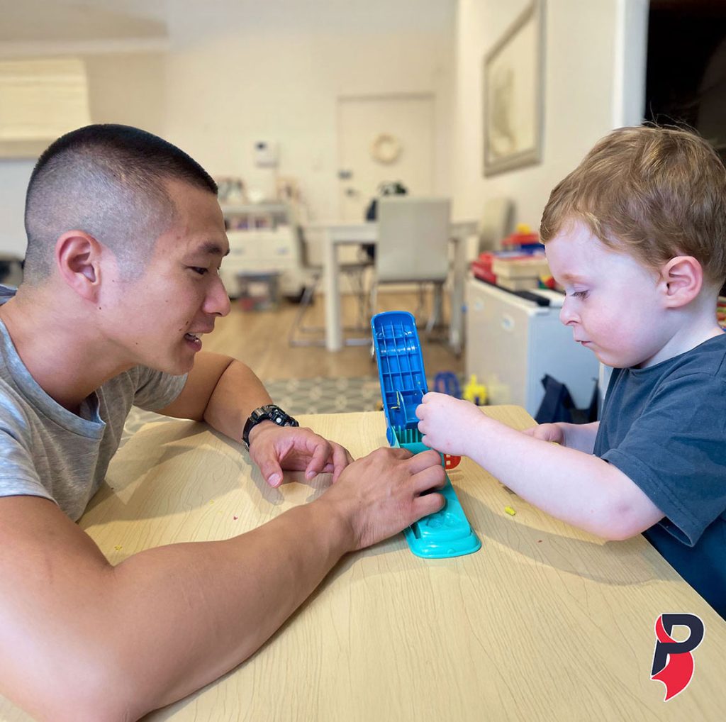 A therapist and a young child playing together at a table